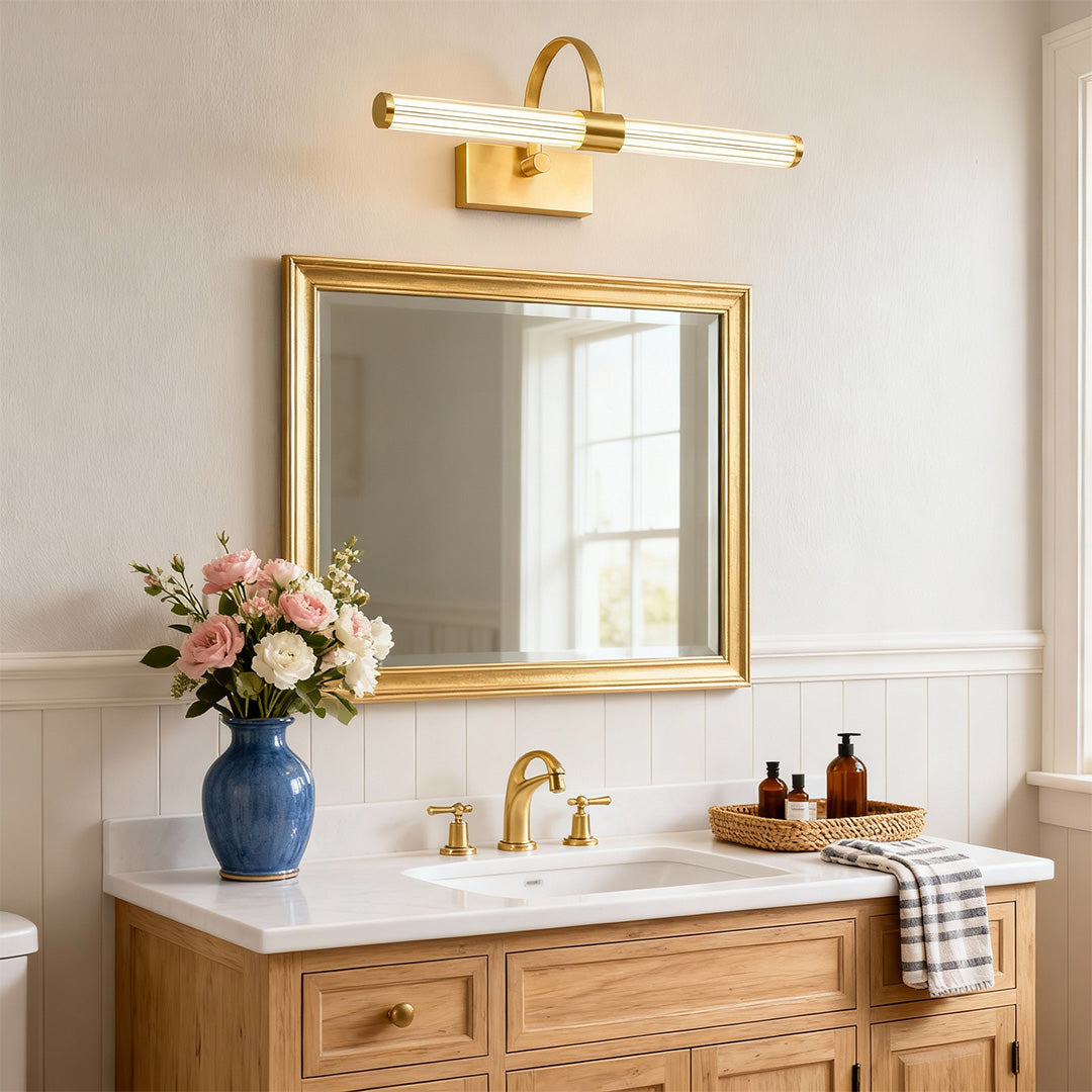 Brass bathroom vanity wall light brightening rustic bathroom with wood vanity and blue vase.