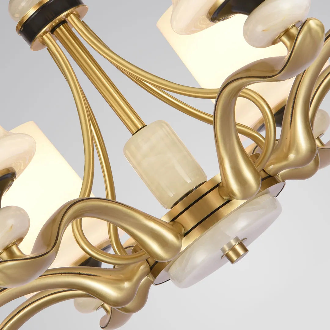 Close-up of brass candle chandelier highlighting the gold brass frame and decorative light arms.