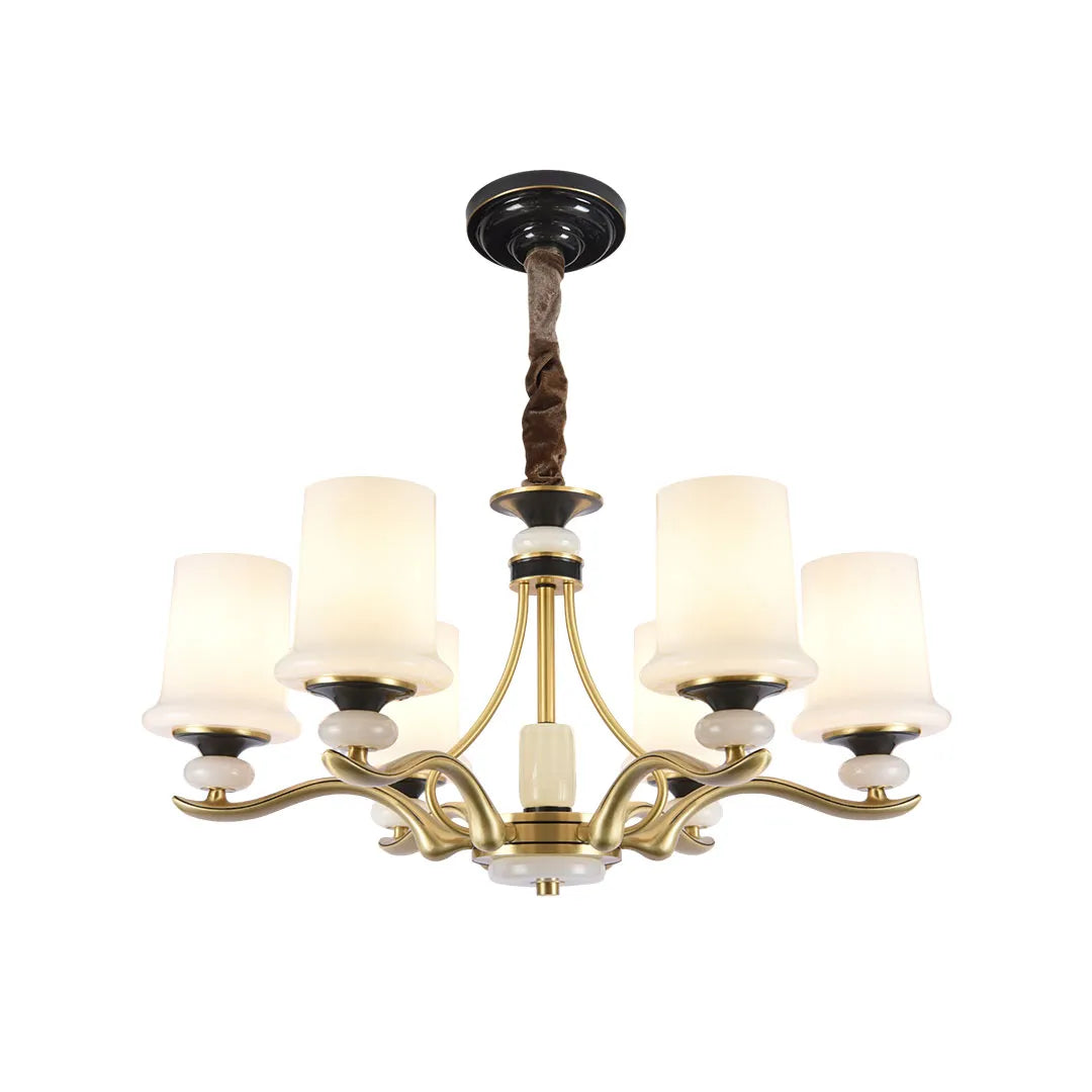 Brass candle chandelier with multiple candle lights and white shades displayed on white background.