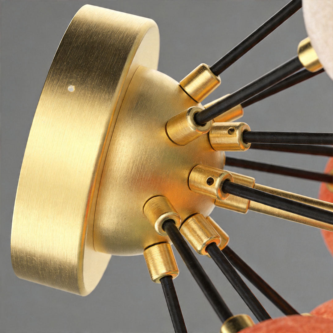 Detailed view of brass ceiling mount base with multiple arms supporting colored glass bulbs.