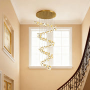 Gold ceiling plate of a modern brass chandelier with suspension wires.