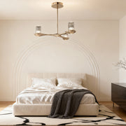 Brass crystal chandelier providing sophisticated lighting in modern master bedroom with textured wall and upholstered bed