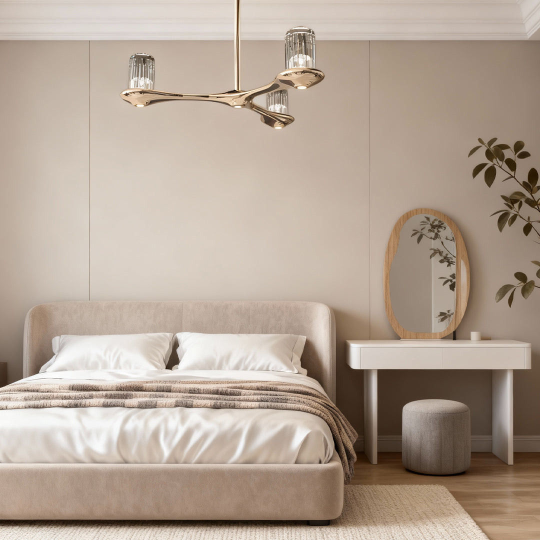 Brass crystal chandelier suspended above bed in neutral-toned bedroom with minimalist contemporary interior design