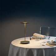Brass dimmable table lamp illuminating elegant dining table with white tablecloth and dinnerware