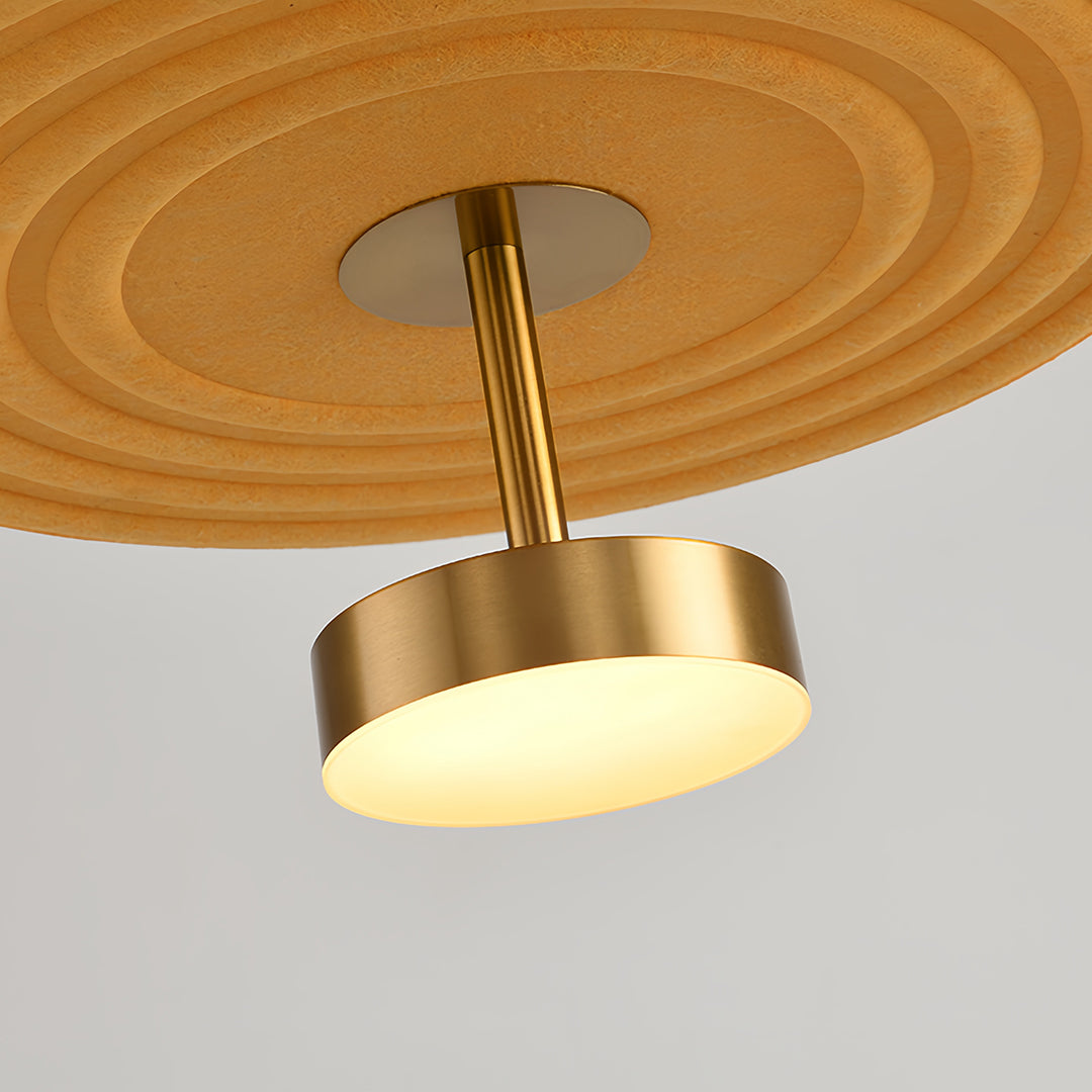 Close-up of the brass fixture detail and bottom yellow layer of a 3 tier chandelier, highlighting the integrated light source.