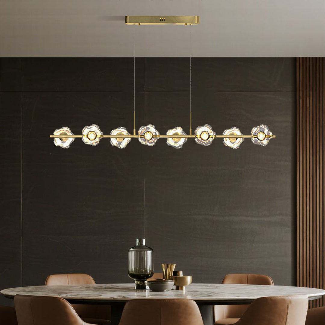 Contemporary linear pendant chandelier with brass frame illuminating upscale restaurant setting with warm glass orbs