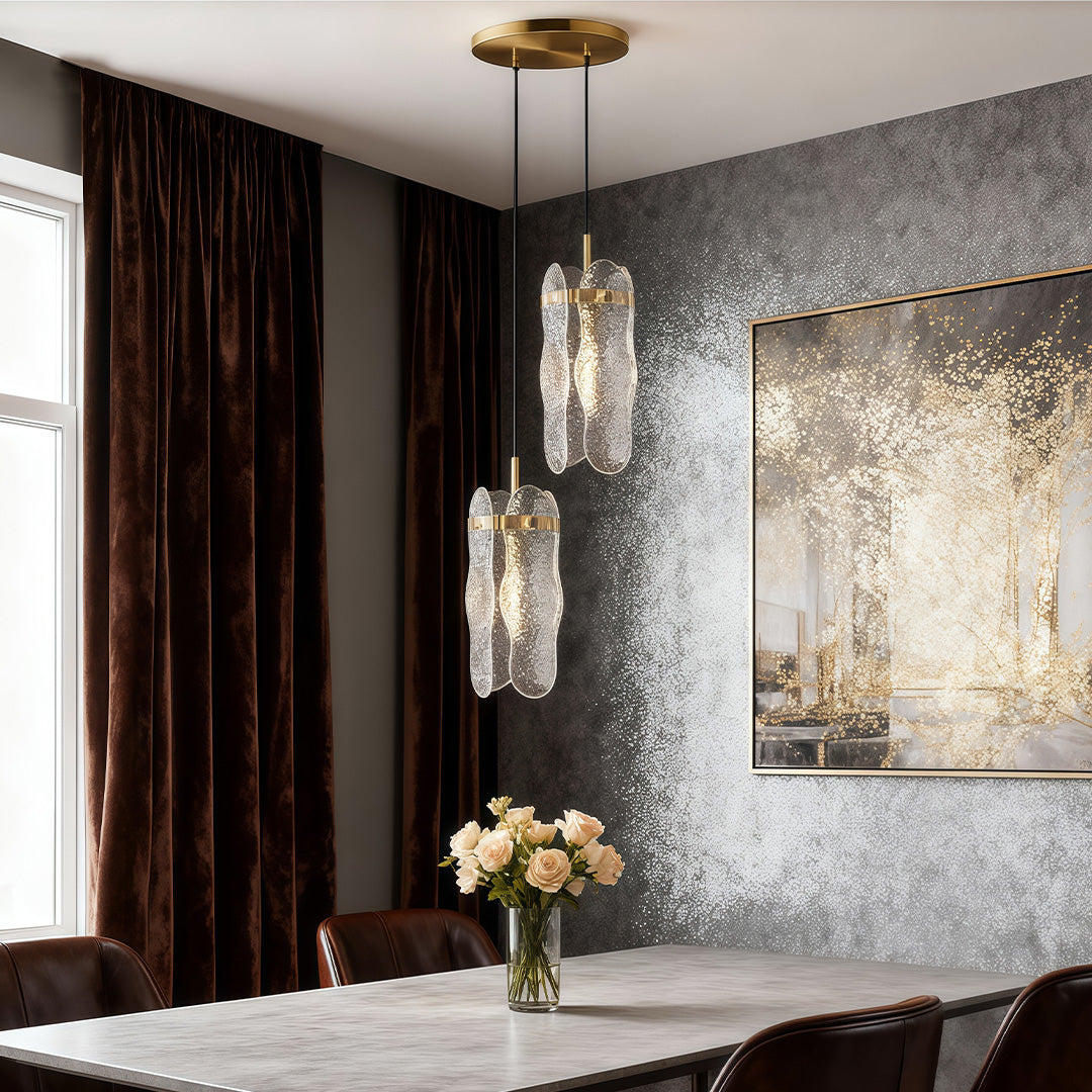 Brass glass pendant light brightening luxurious bedroom with brown curtains and silver accent wall.