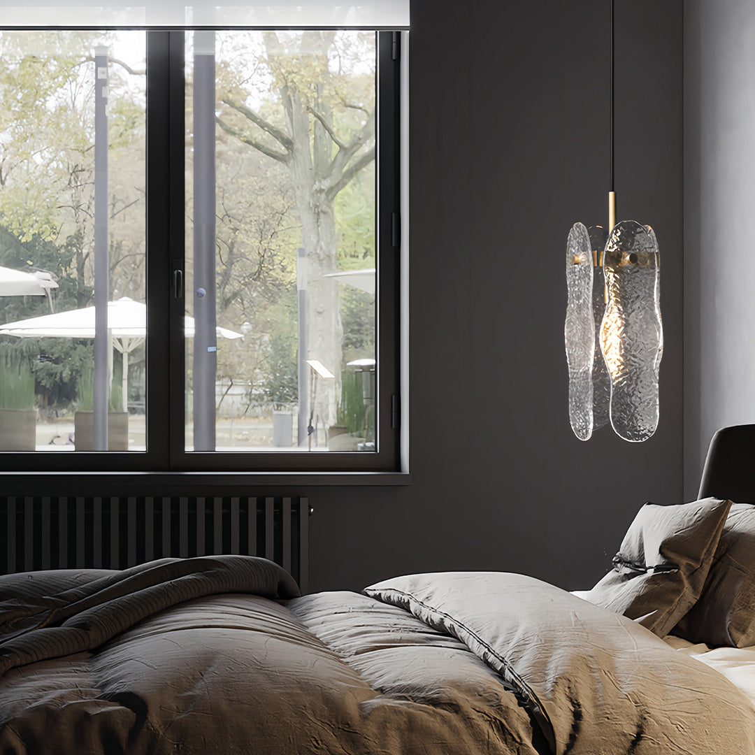 Brass glass pendant light enhancing modern bedroom with dark walls and natural window light.