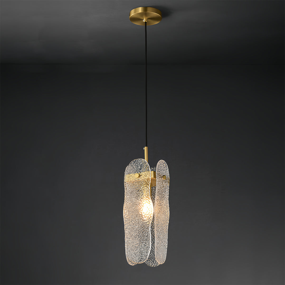 Brass glass pendant light with warm LED glow displayed against dark moody background.