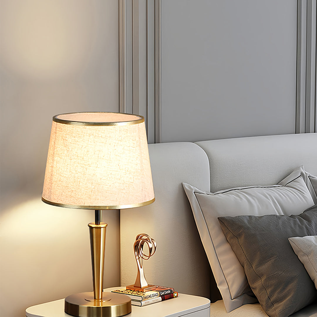 Stylish brass table lamp providing ambient lighting in contemporary bedroom setting