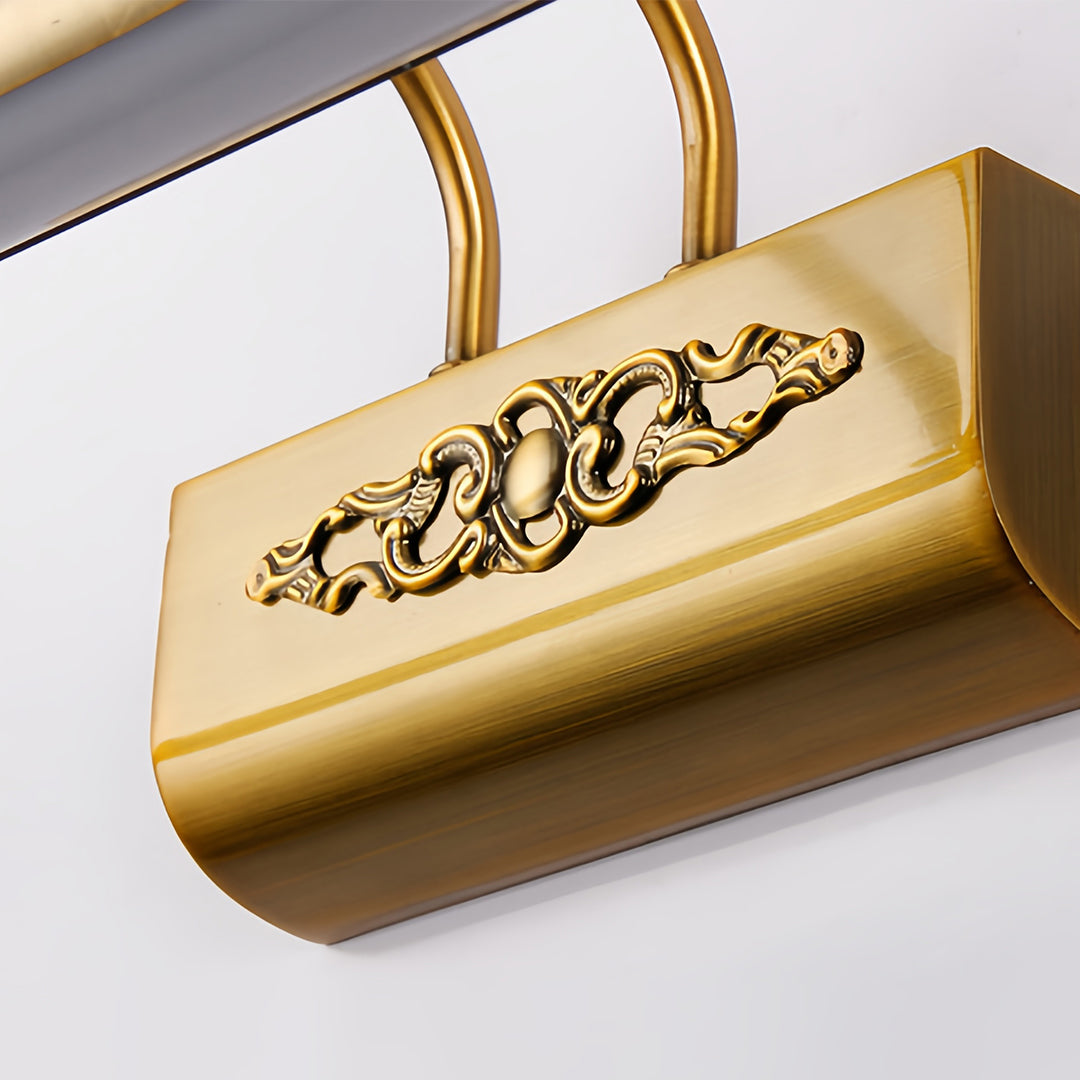 Close-up detail of brass bathroom vanity light fixtures showing decorative filigree work pattern