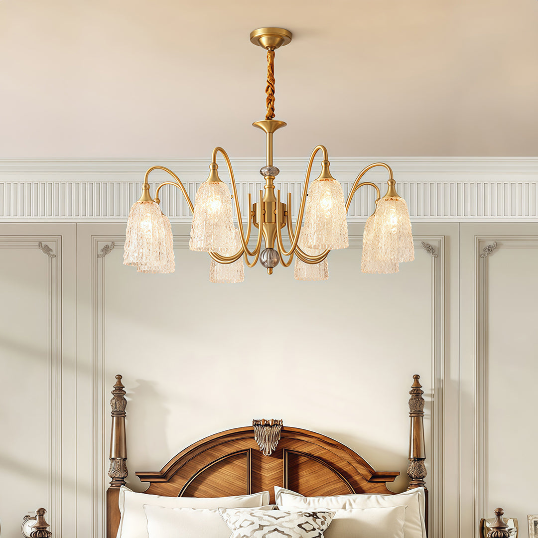 Brass vintage chandelier installed in a luxurious bedroom, providing warm and inviting illumination.