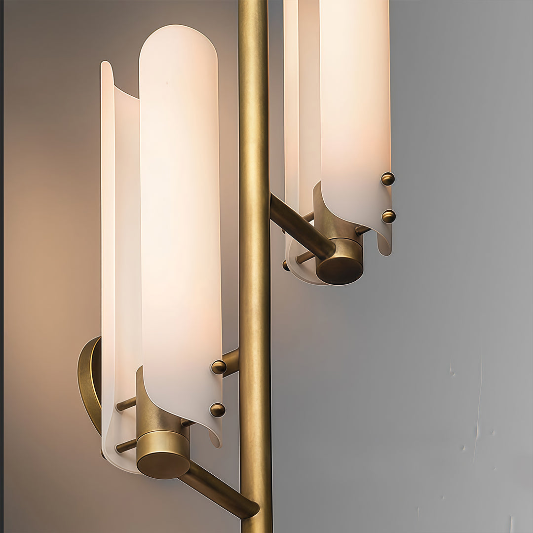 Brass wall light with glass shade mounted on door frame showing vertical tube design.