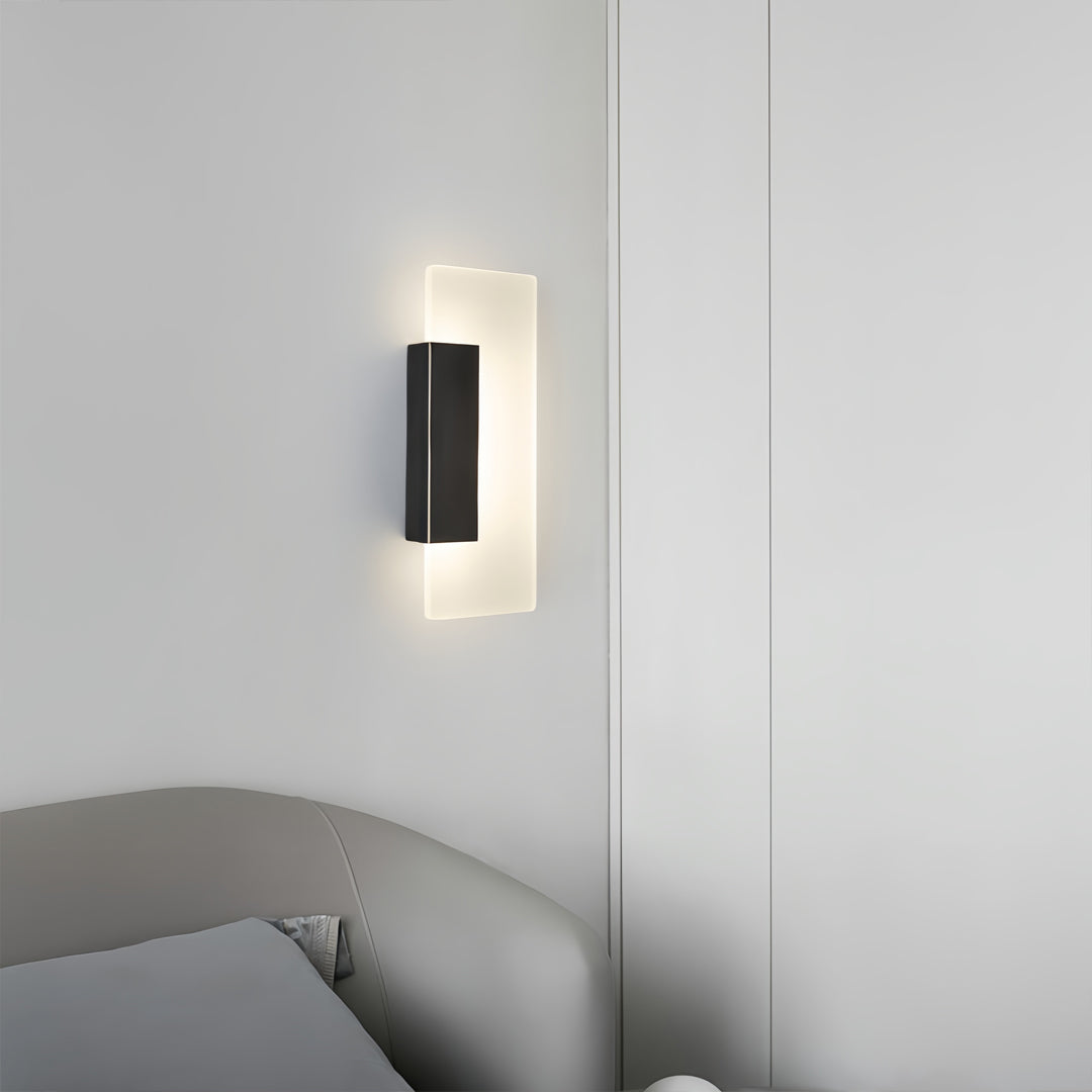 Brass wall lights providing accent lighting on gray concrete wall in minimalist contemporary interior setting