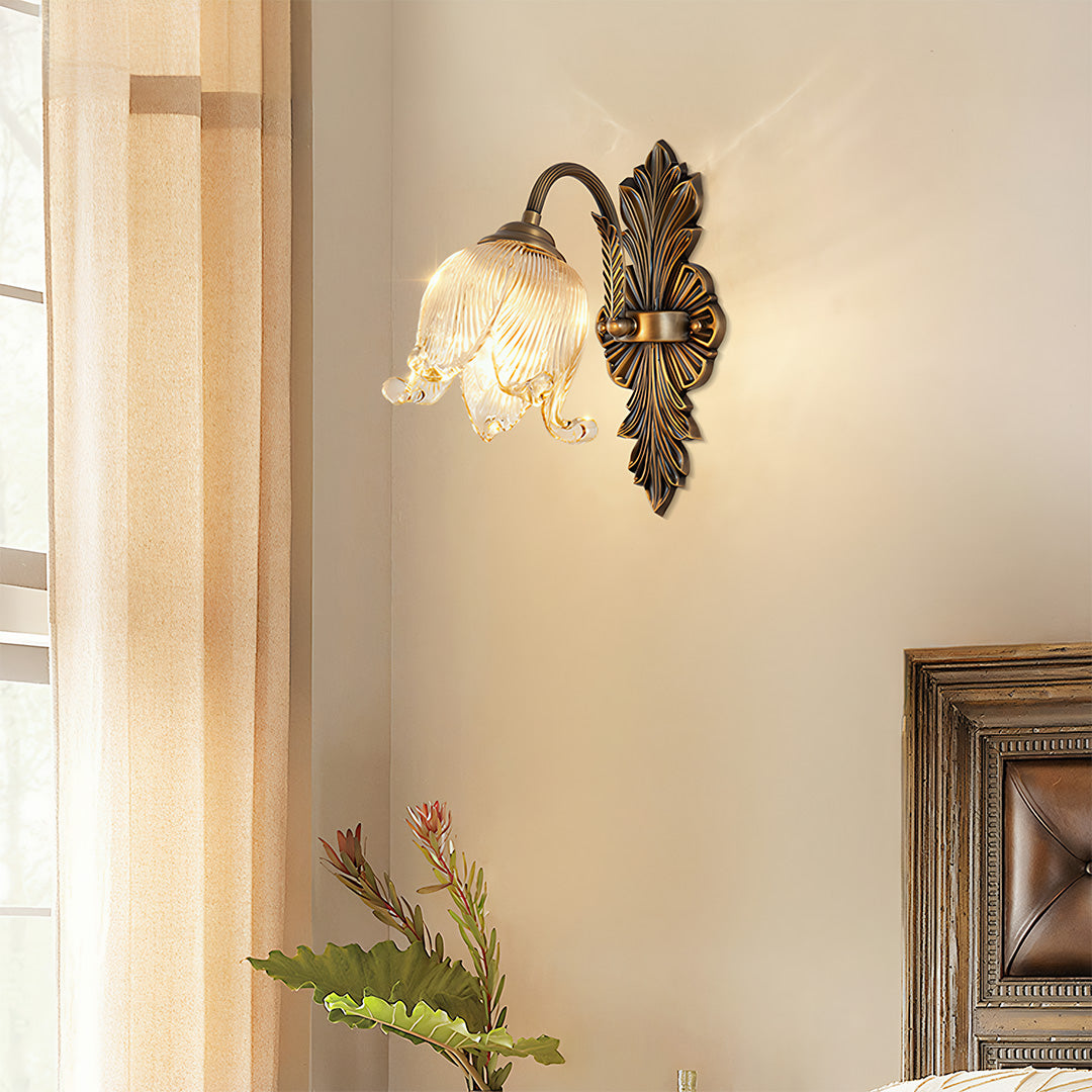 Brass wall lights providing accent lighting in hallway with white wainscoting and wooden door