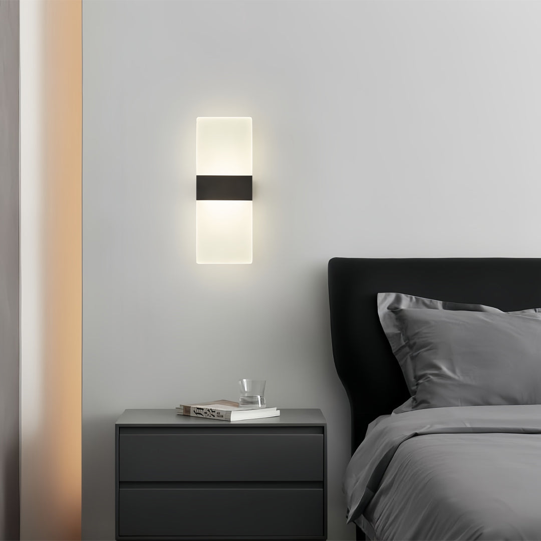 Brass wall lights creating warm glow beside bed in contemporary bedroom with neutral tones and minimalist styling