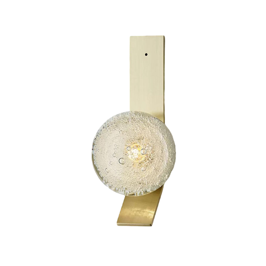 Contemporary brass wall sconce with textured glass globe providing elegant ambient lighting