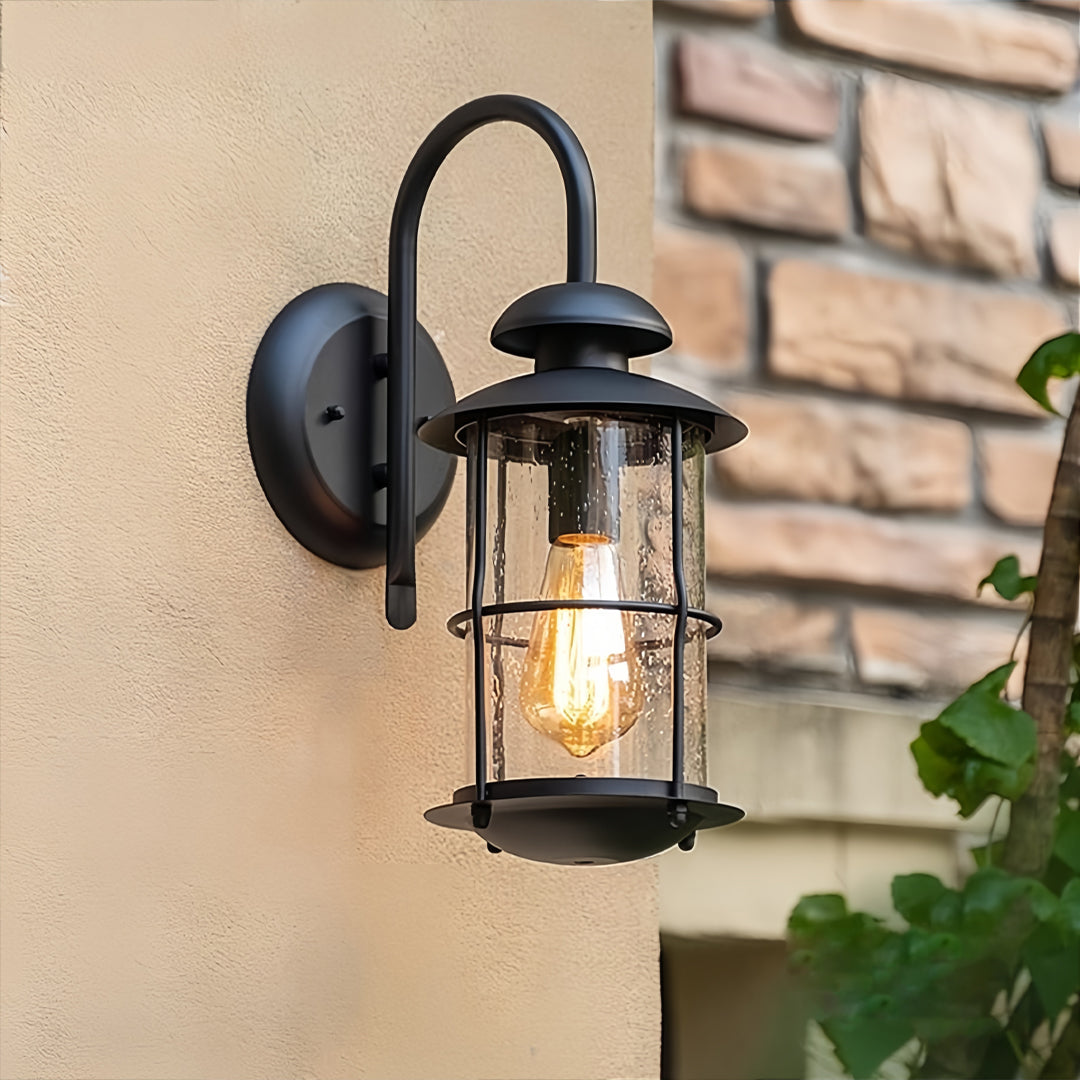 Outdoor wall mount light fixtures installed on a brick wall with glowing vintage bulb.