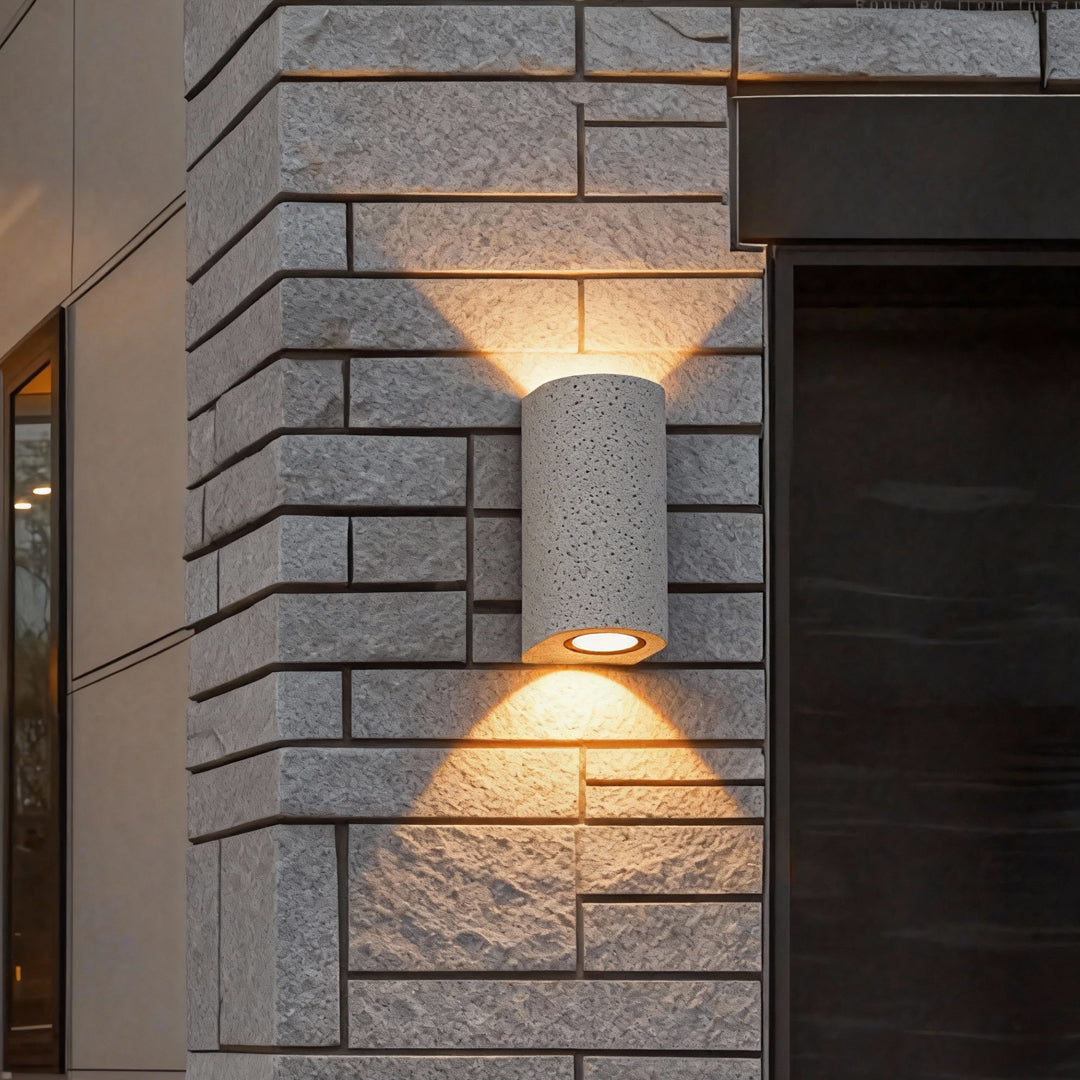 Brick wall installation featuring textured cylindrical up down wall lights for architectural accent lighting.