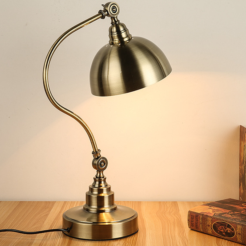 A classic copper table lamp with an adjustable body on a side table.
