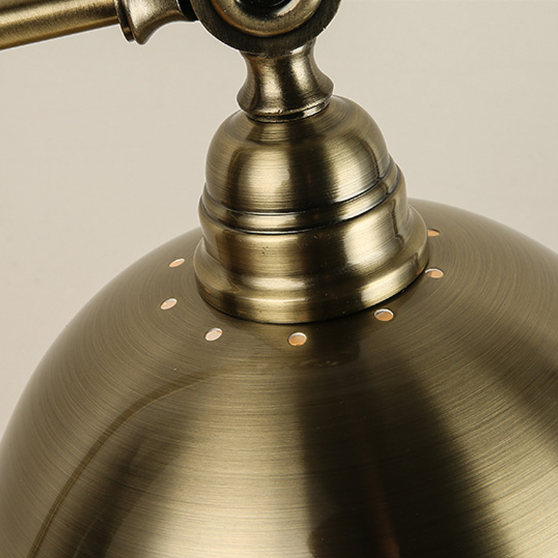 Bronze desk lamp arm connection and metal texture close up.