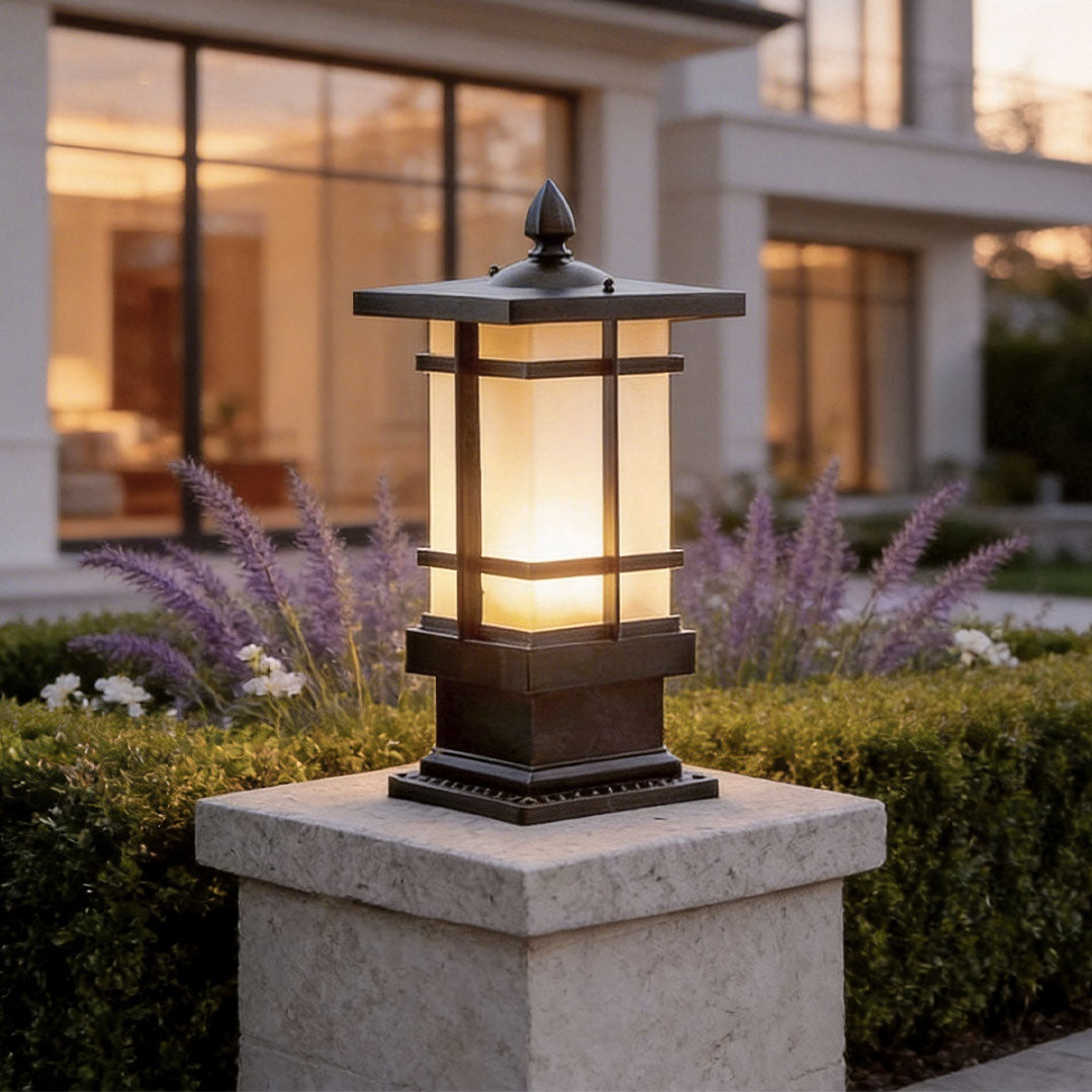 Unique garden bollard lighting with a bronze metal frame and frosted glass on stone pillars.