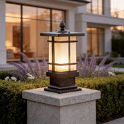Unique garden bollard lighting with a bronze metal frame and frosted glass on stone pillars.