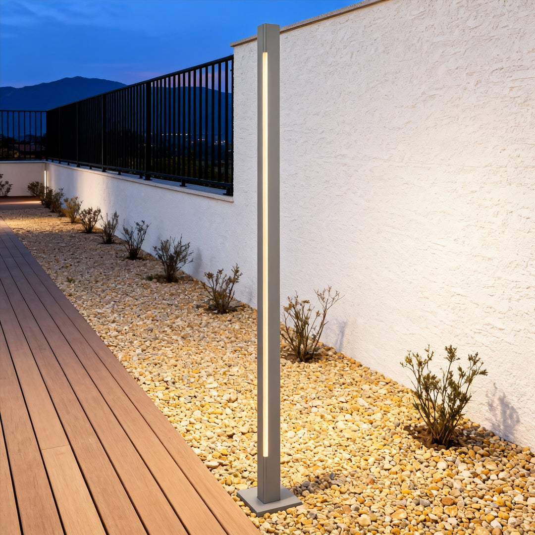 Warm bronze led bollard light fixtures installed beside a garden walkway, highlighting plants and stone edges.
