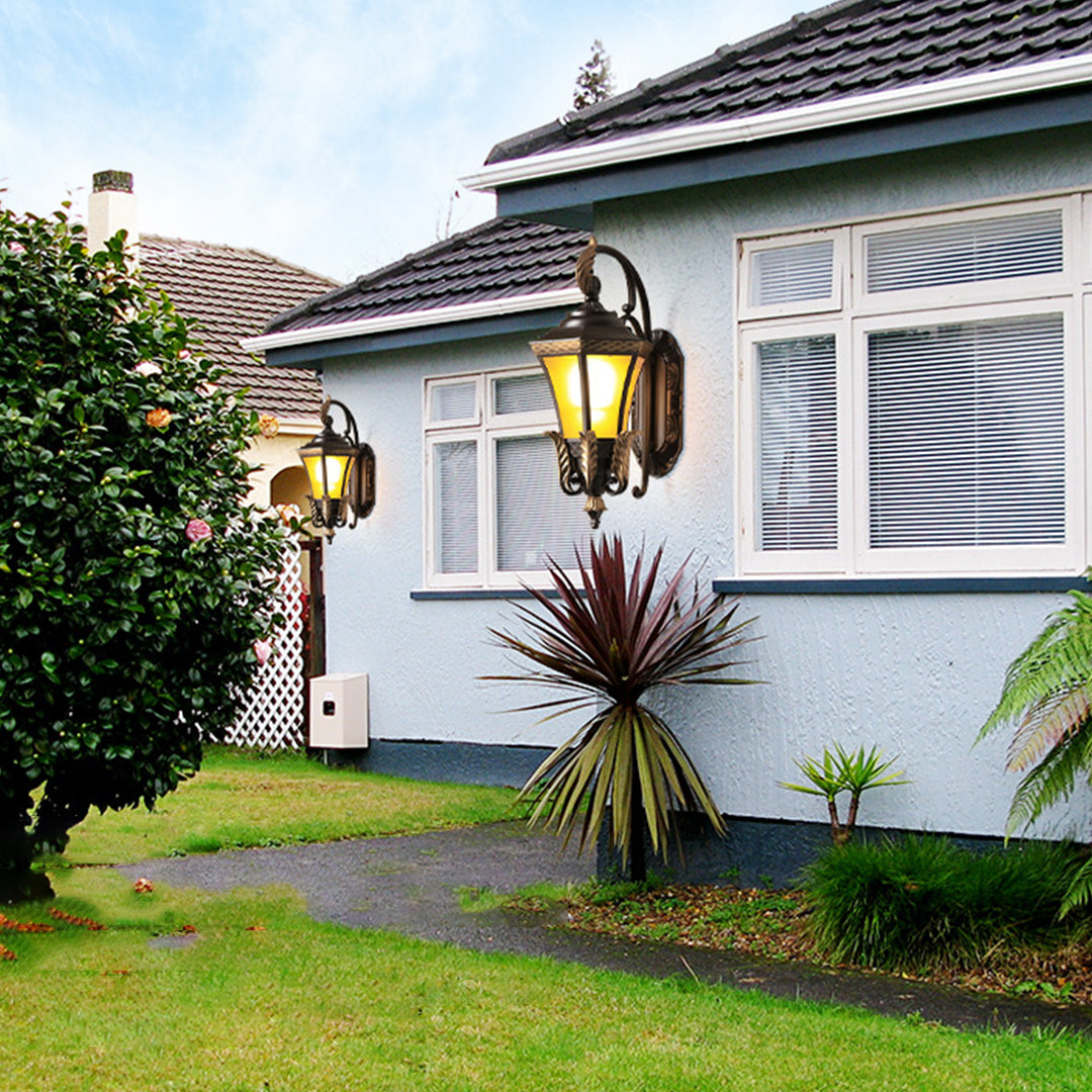 Traditional bronze lantern with decorative leaf motifs and warm illumination creating elegant entrance lighting for upscale home