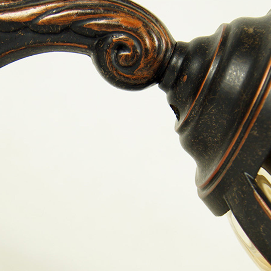 Close-up detail of ornate bronze lantern showing decorative scrollwork and metalwork craftsmanship