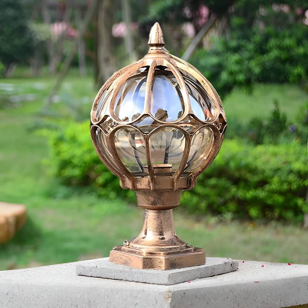Bronze outdoor globe pillar lights mounted on a concrete column in a garden environment.