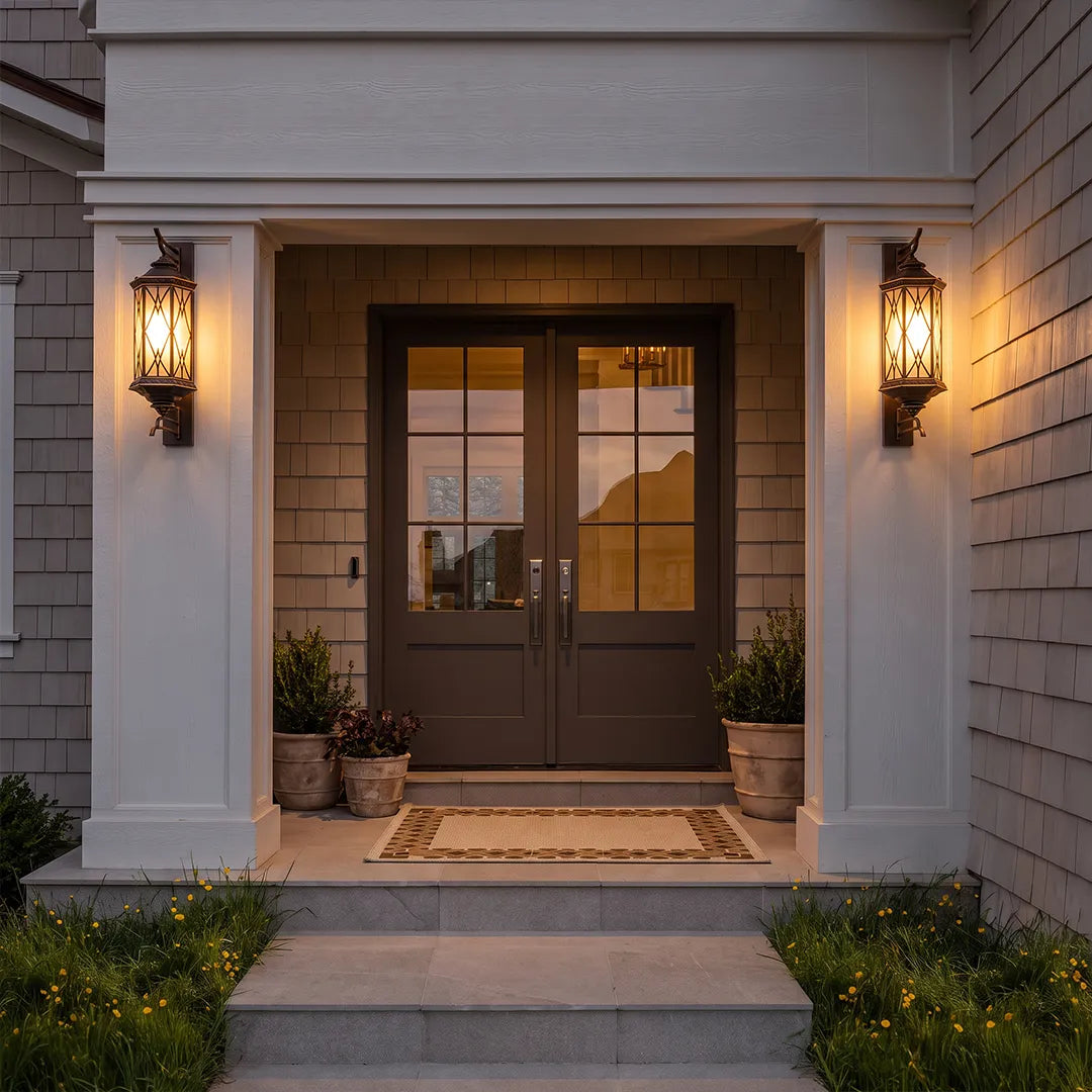 Bronze outdoor sconce flanking a front entry door, creating a welcoming and symmetrical exterior lighting design.
