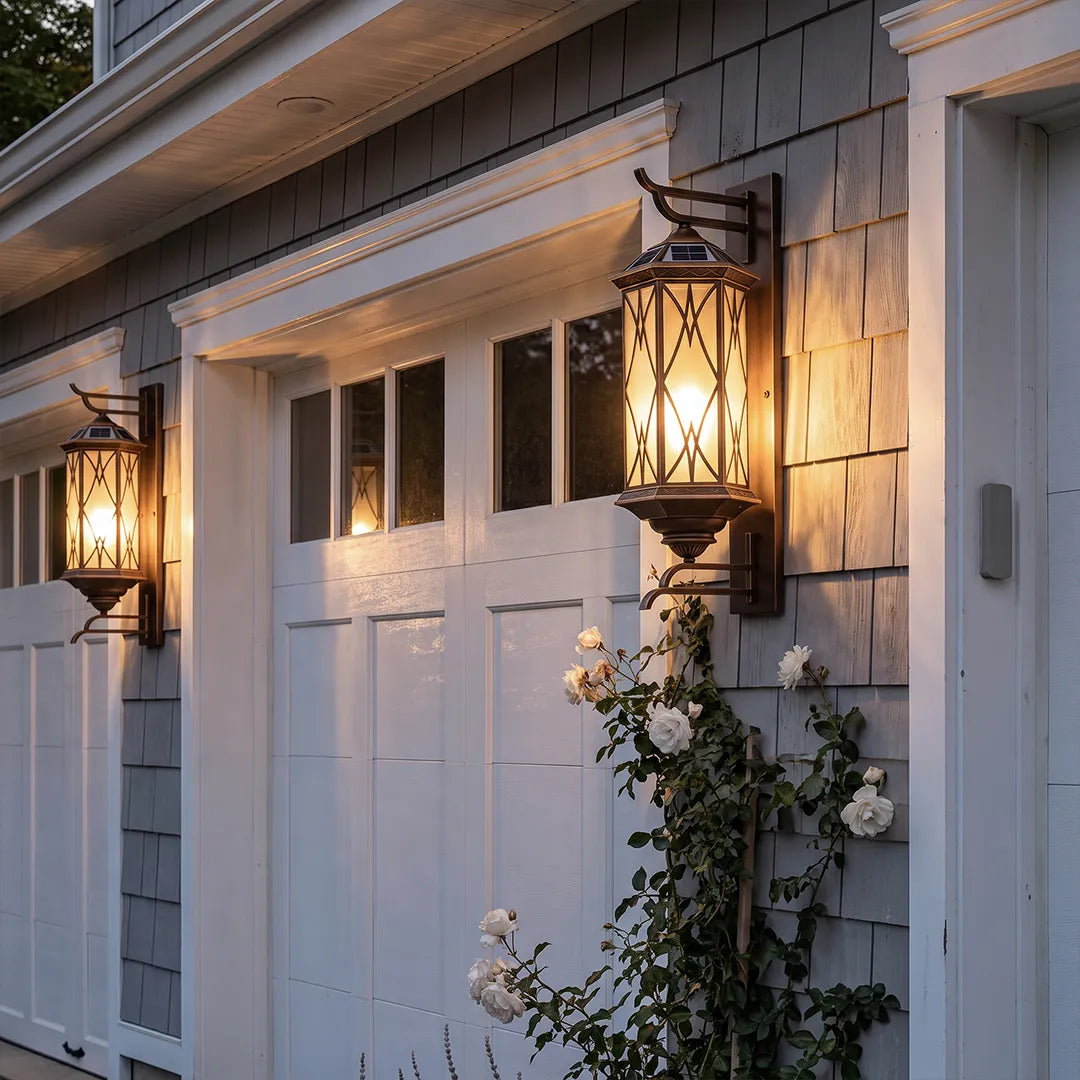 Bronze outdoor sconce mounted beside a garage door, adding warm lantern-style lighting to the exterior wall.
