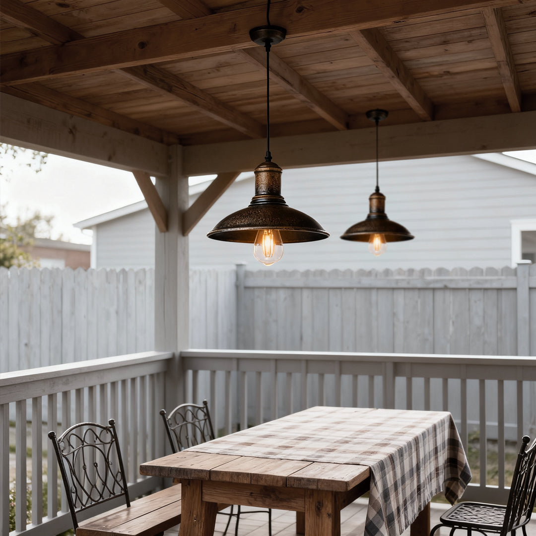 Bronze pendant lighting fixture hanging above an outdoor dining table, enhancing the rustic patio.