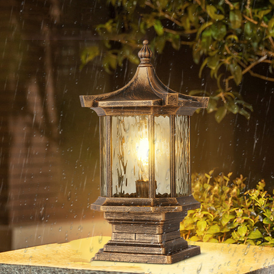 Traditional bronze post light with vintage glass creating ambient garden lighting among foliage