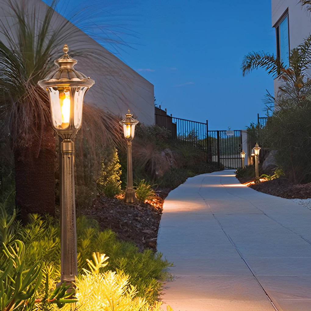 Bronze street lamp providing soft illumination along a stylish outdoor walkway.