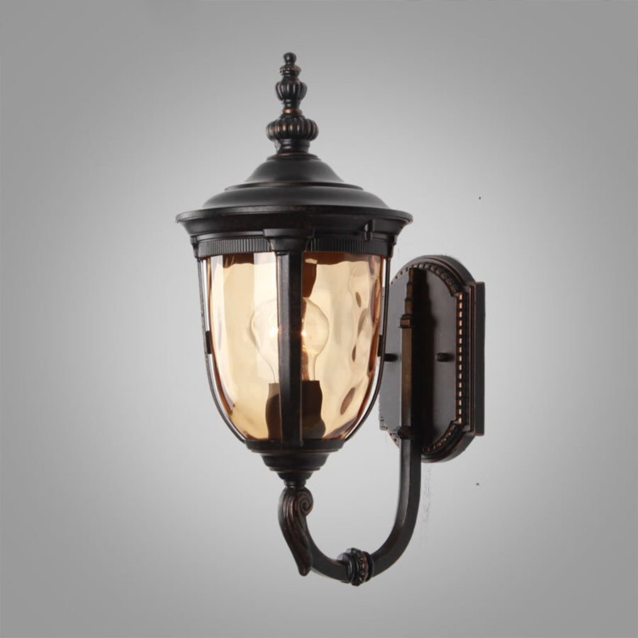 Dark bronze wall lantern with seeded glass panels mounted on neutral background
