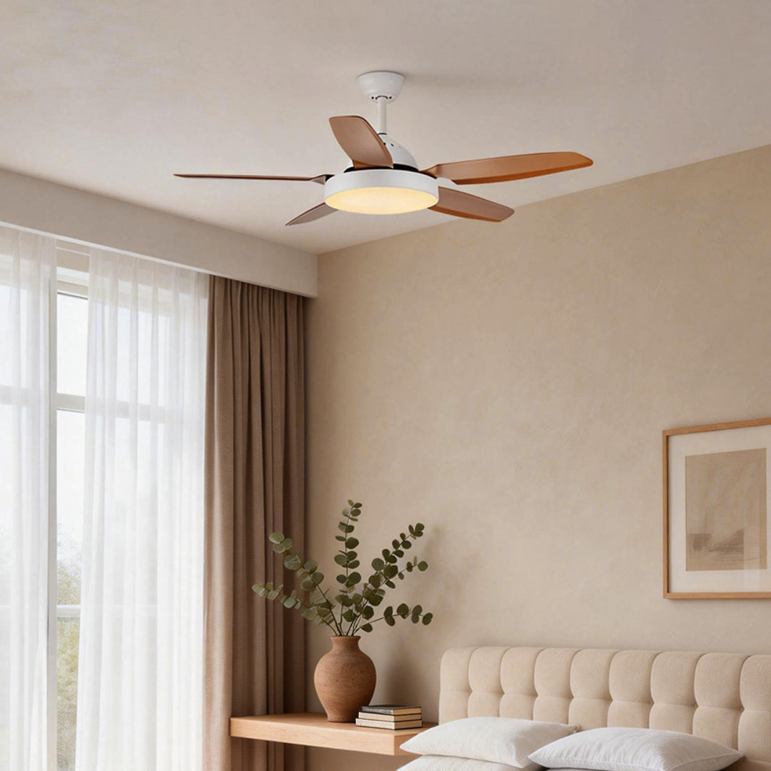 Brown ceiling fan with light illuminating a cozy living room with a tufted sofa.