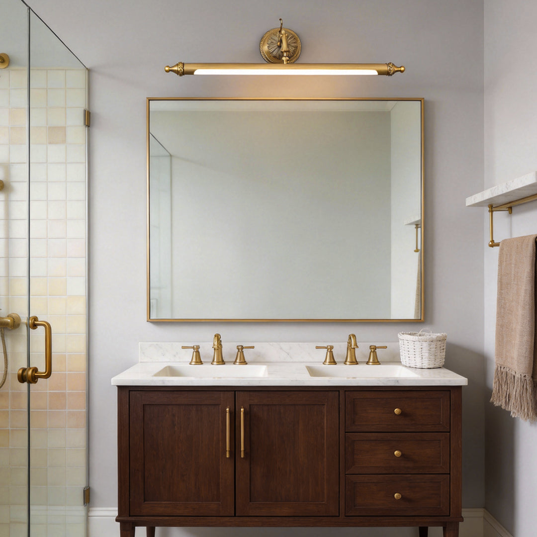 Brushed gold vanity light bar above a double sink bathroom vanity