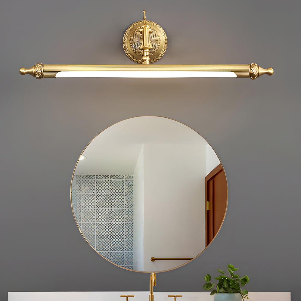 Brushed gold vanity light bar mounted above a round bathroom mirror