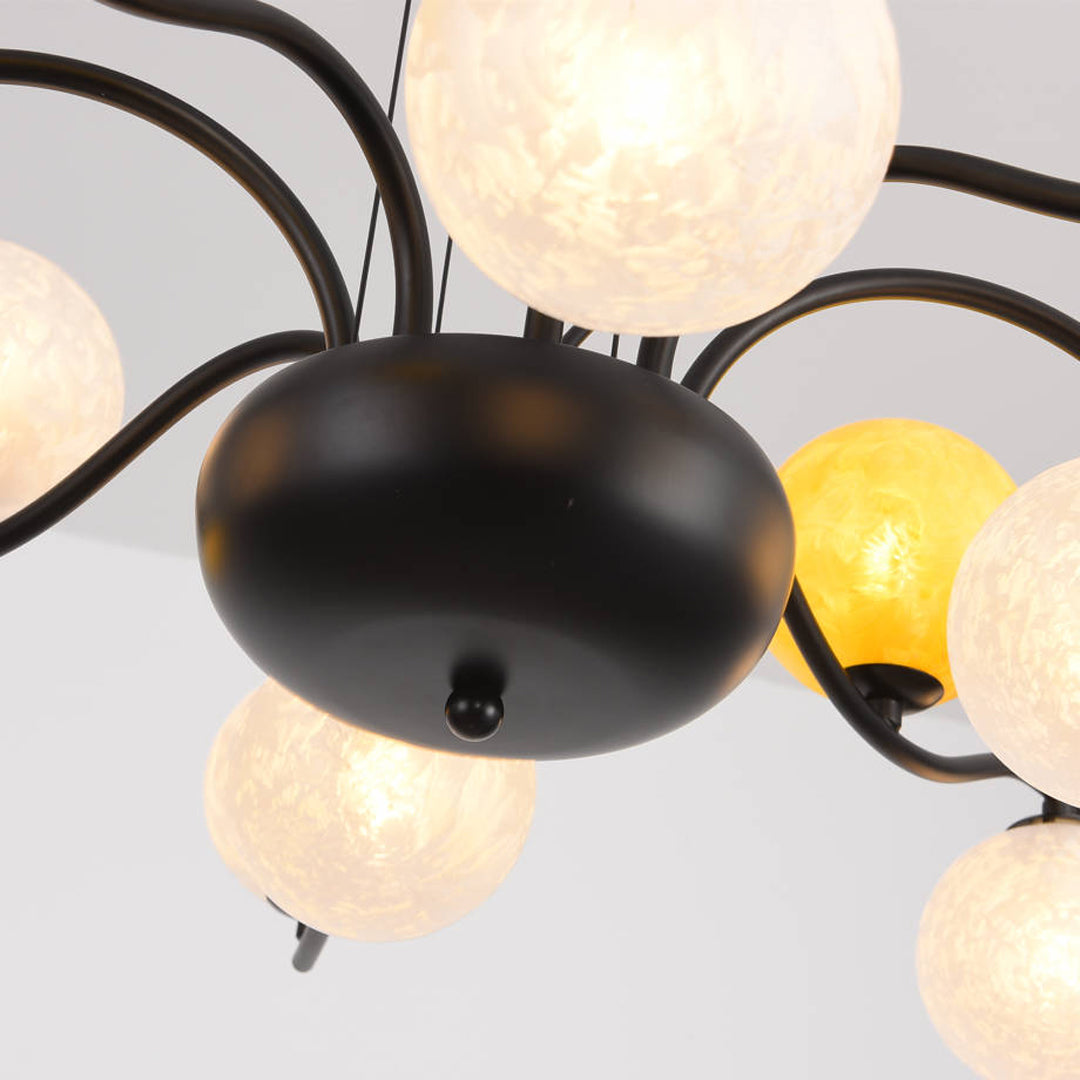 Detailed view of chandelier arm connections and glass globe arrangement on a matte black base.