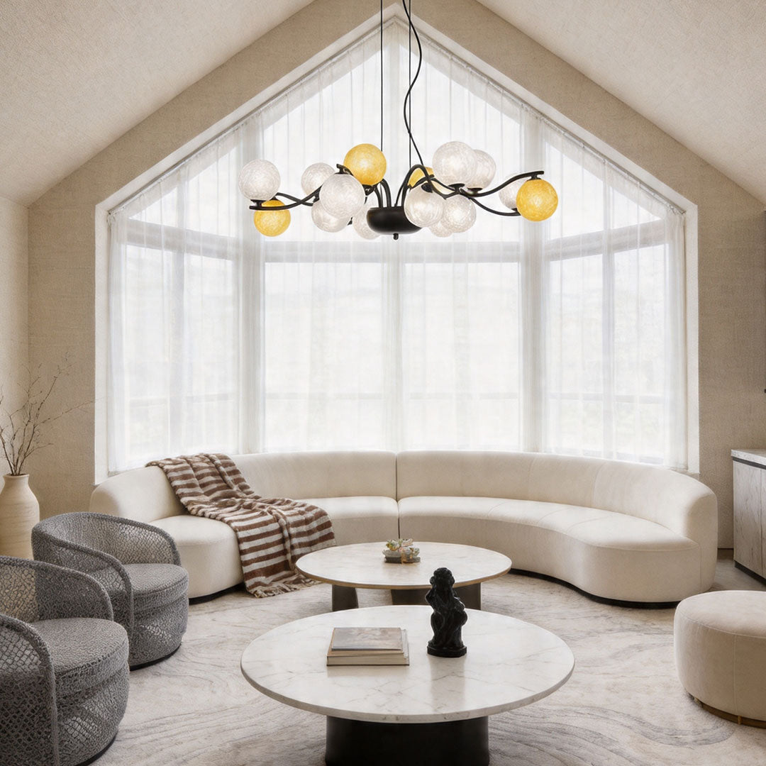 Bubble chandelier lighting installed in a spacious living room with large windows and soft neutral furnishings.