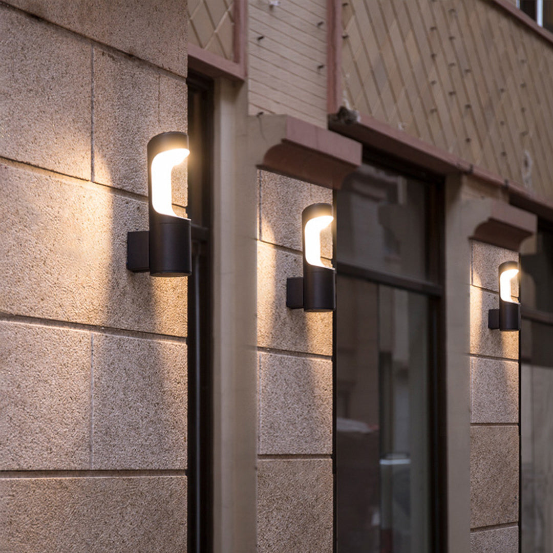 Outdoor wall sconce lighting fixtures installed at a building entrance, creating inviting warm illumination.