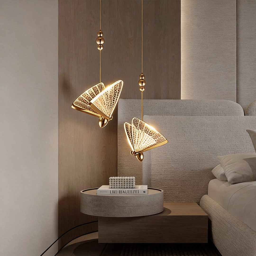Butterfly pendant light above bedside table with warm gold finish and textured glass wings.