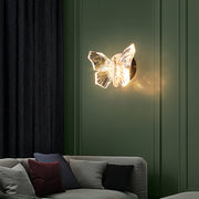 Illuminated butterfly wall light creating ambient glow in modern green bedroom interior setting