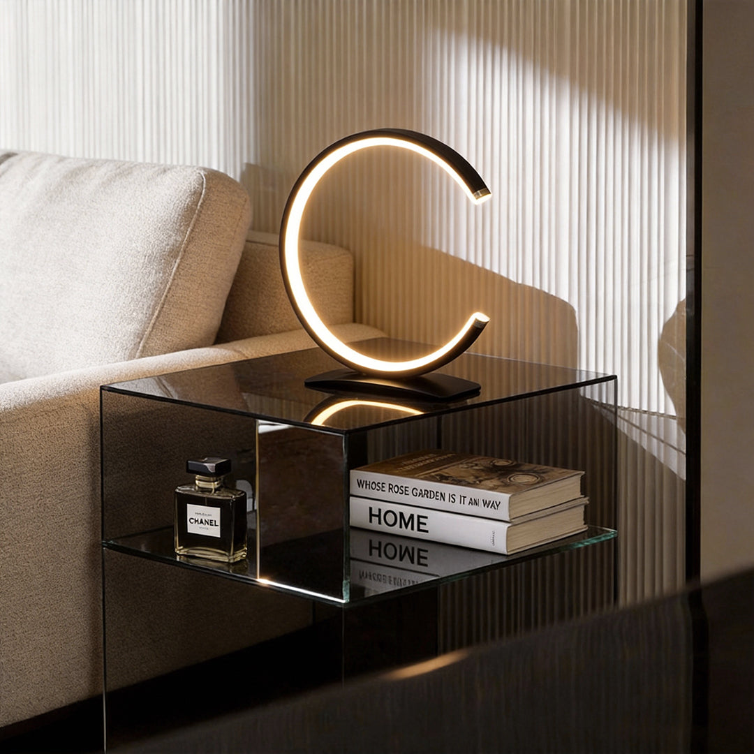 C shaped table lamp illuminating a modern bedside table with warm, ambient glow.