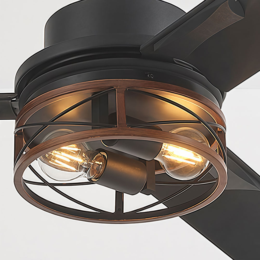 Close-up of black ceiling fan with lighting showing the decorative cage and warm exposed bulbs.