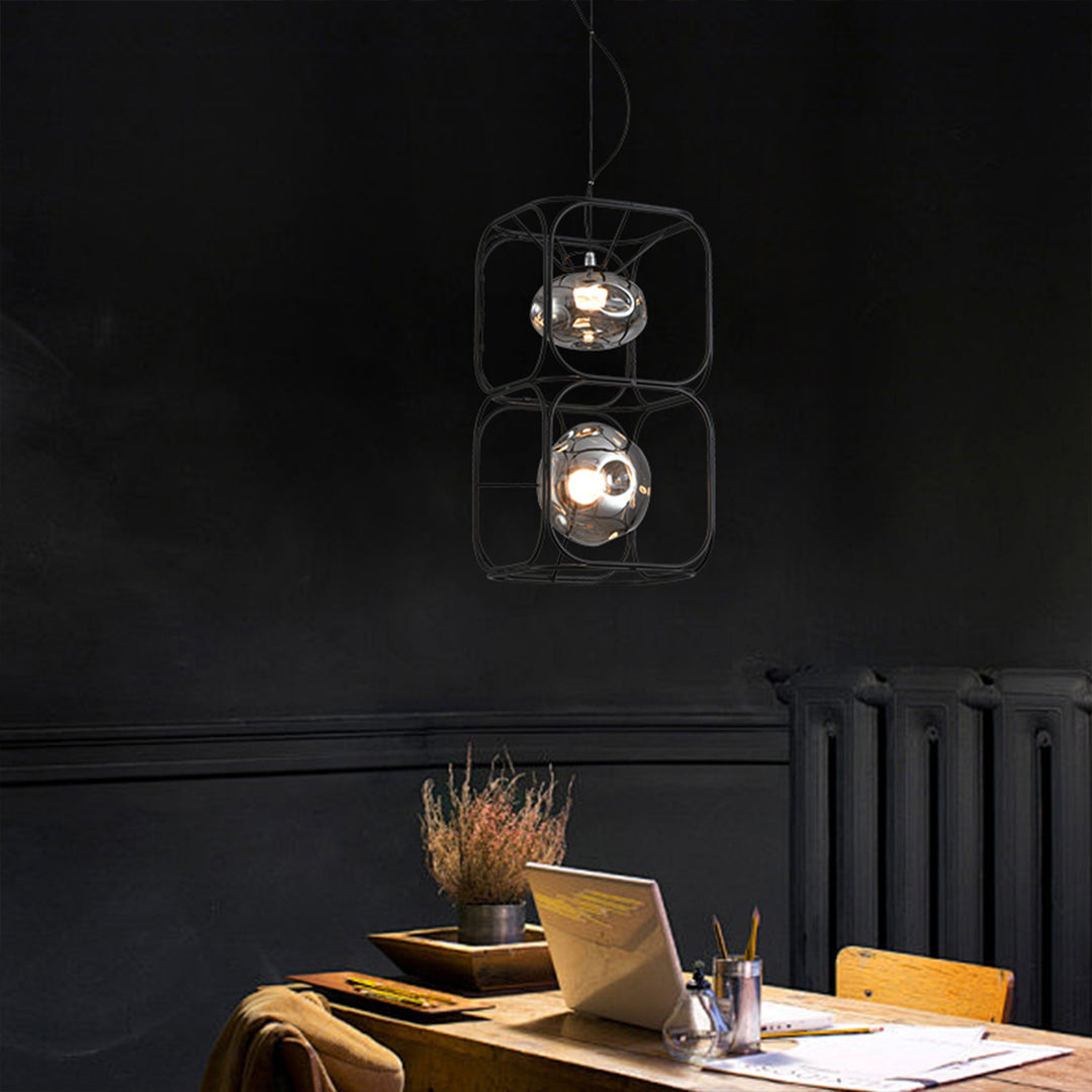 Caged pendant light illuminating a dark toned dining space, highlighting the table with focused warm light.