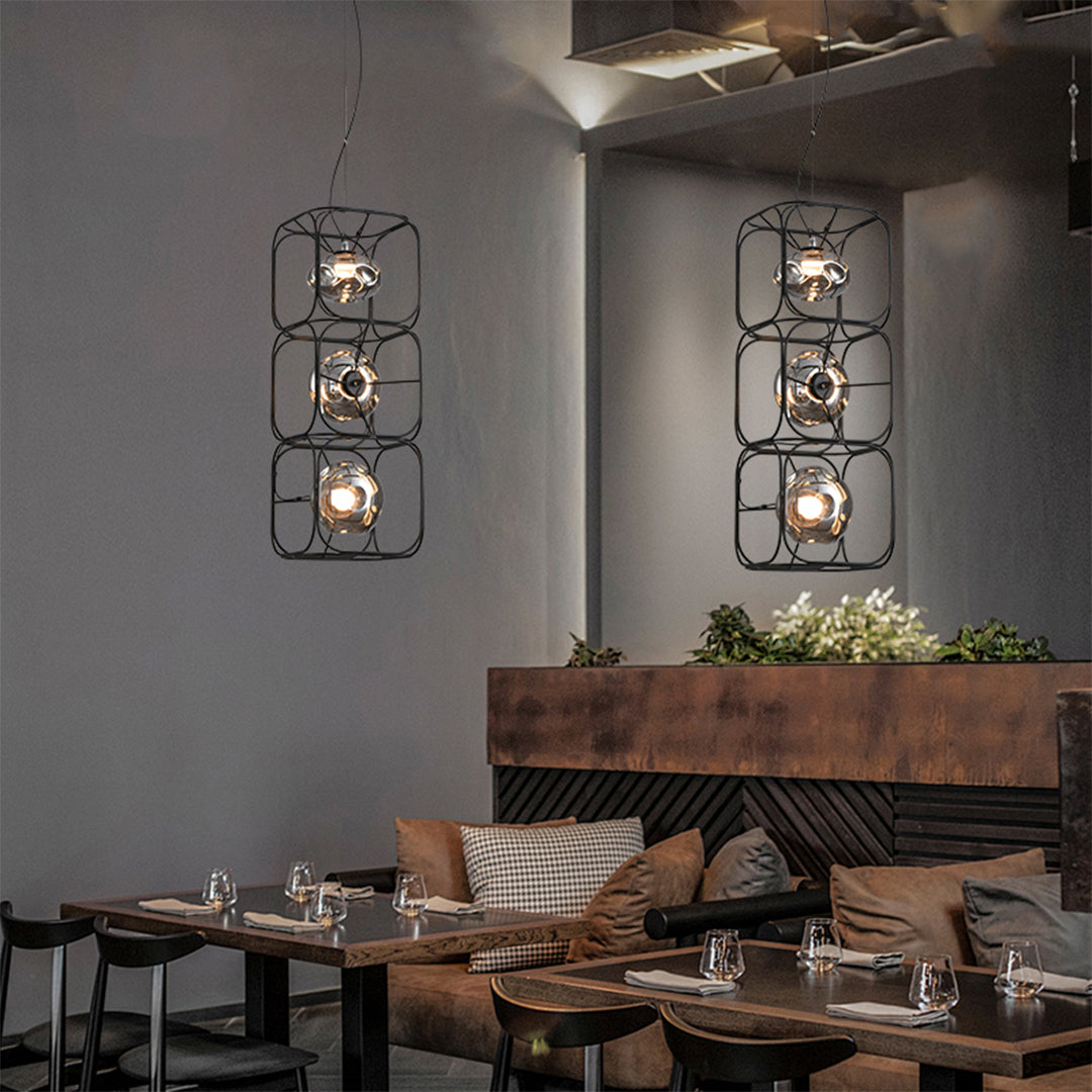 Twin caged pendant light fixtures mounted above a restaurant seating area, offering balanced and decorative illumination.