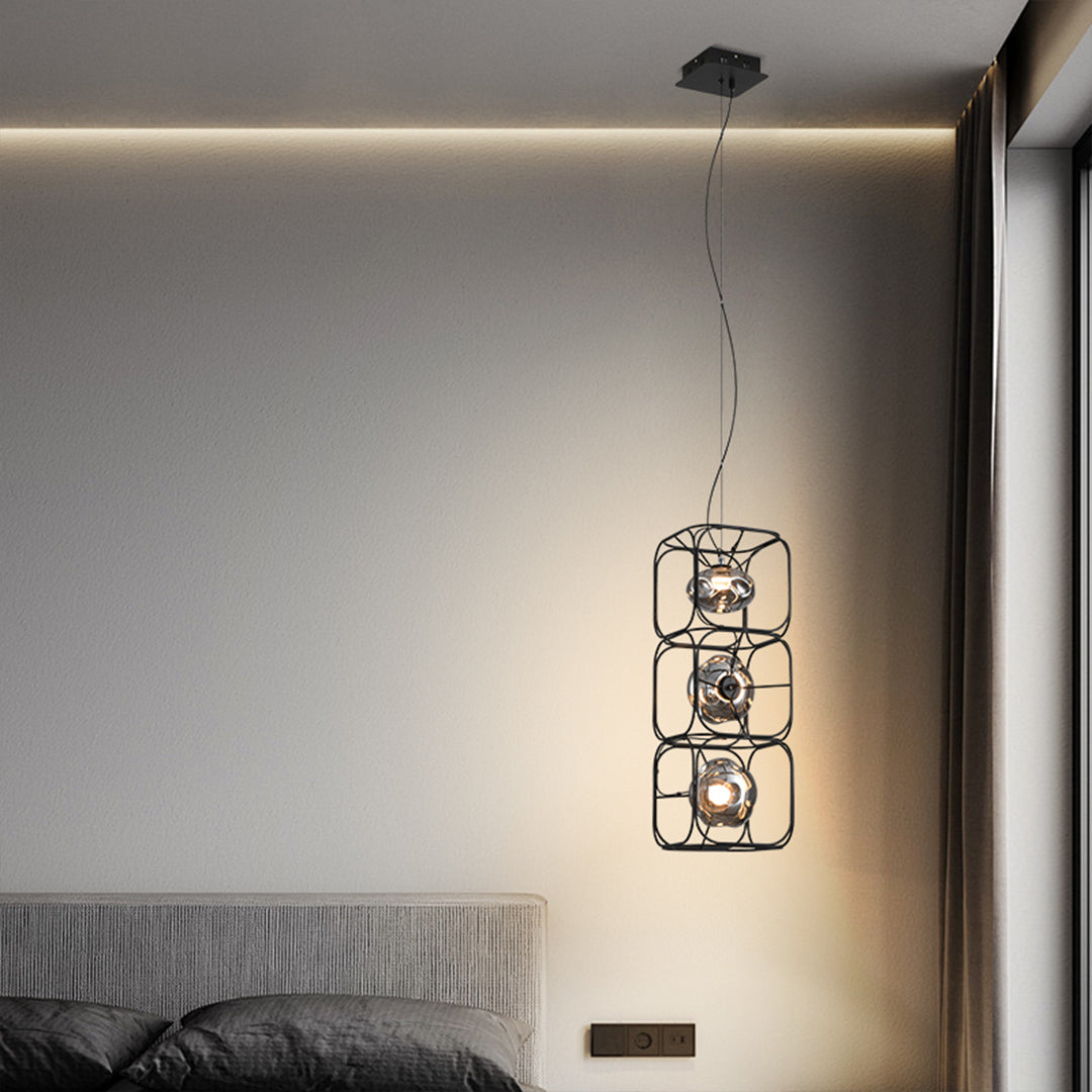 Vertical arrangement of caged pendant light fixtures above a bed, adding layered lighting and a modern decorative accent.